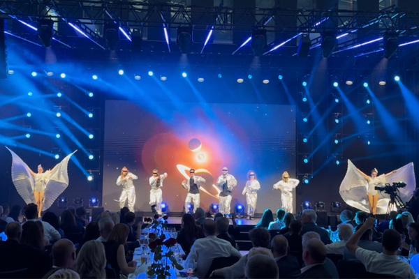 Tänzer Gruppe in weißen Outfits performt auf der Bühne bei einem Firmenevent